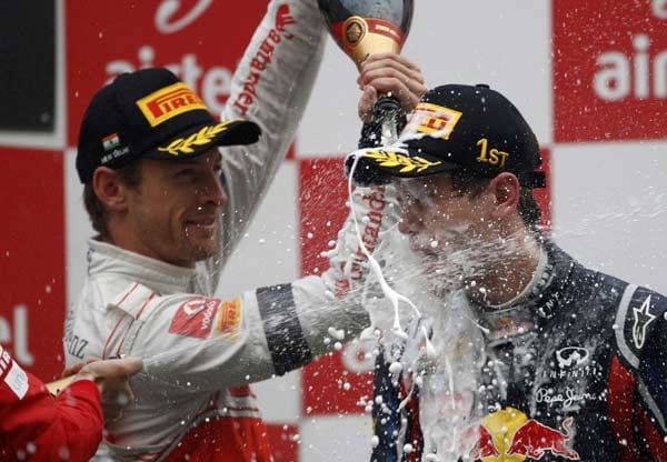 Ehre, wem Ehre gebührt. Die Kollegen auf dem Siegerpodest geben Formel-1-Weltmeister Sebastian Vettel das (Champagner)-Fläschchen.