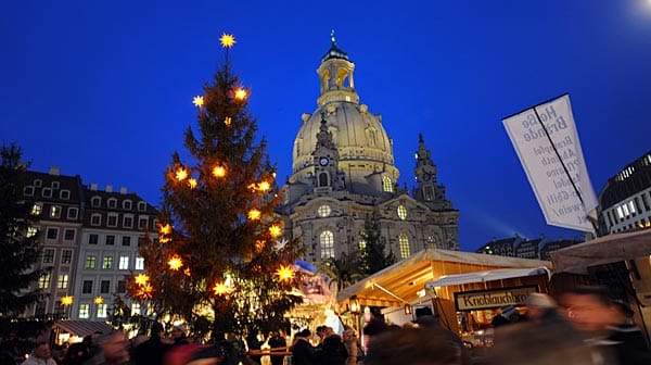 Vor der Kulisse der Dresdner Frauenkirche gehen Gäste des Weihnachtsmarktes über den Neumarkt.
