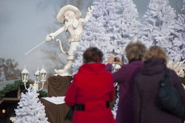 Touristen fotografieren eine Märchenfigur aus dem gleichnamigen Märchen "Der gestiefelte Kater" im Funkelmarkt der weihnachtlichen Erlebniswelt 1000 Funkel.