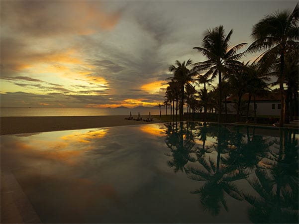 Sonnenuntergang am Pool des Hotels The Nam Hai - es gilt als eines der besten Häuser in Südostasien.