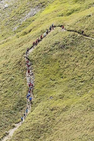 Hintereinander laufen oder walken die 500 Teilnehmer schmale Bergpfade der Alpen hoch.