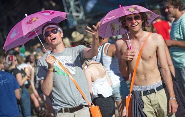 Pinkfarbene Regencapes im Norden, pinkfarbene Sonnenschirme im Süden. Pinkfarbene Regencapes im Norden, pinkfarbene Sonnenschirme im Süden.