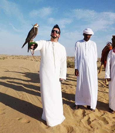 In der Wüste von Dubai lässt er es sich auch nicht nehmen, sich einen Falken auf den Arm setzen zu lassen.