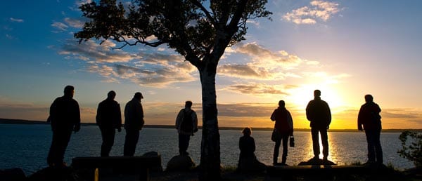 Menschen stehen im Sonnenuntergang am Ufer des Sedlitzer Sees im gleichnamigen südbrandenburgischen Ort Sedlitz.