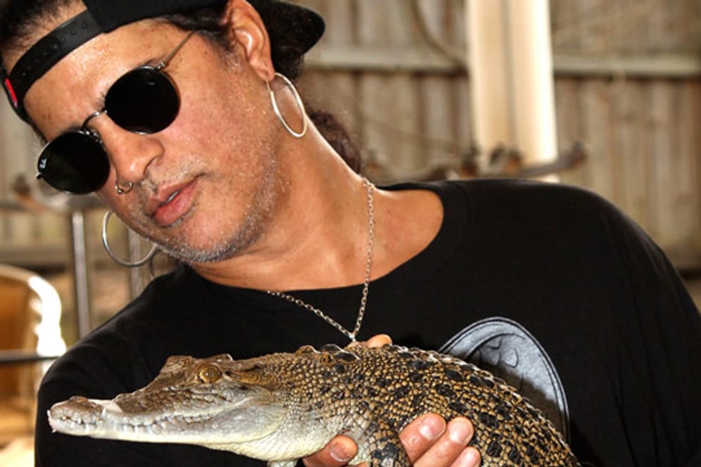 Wie seine Gitarre hat Slash auch das Baby-Krokodil fest im Griff.