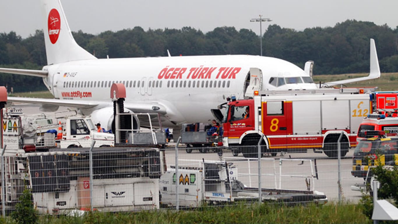 Rettungskräfte versorgen verletzte Passagiere neben der Maschine, die für "Öger Türk Tur" in die Türkei fliegen sollte