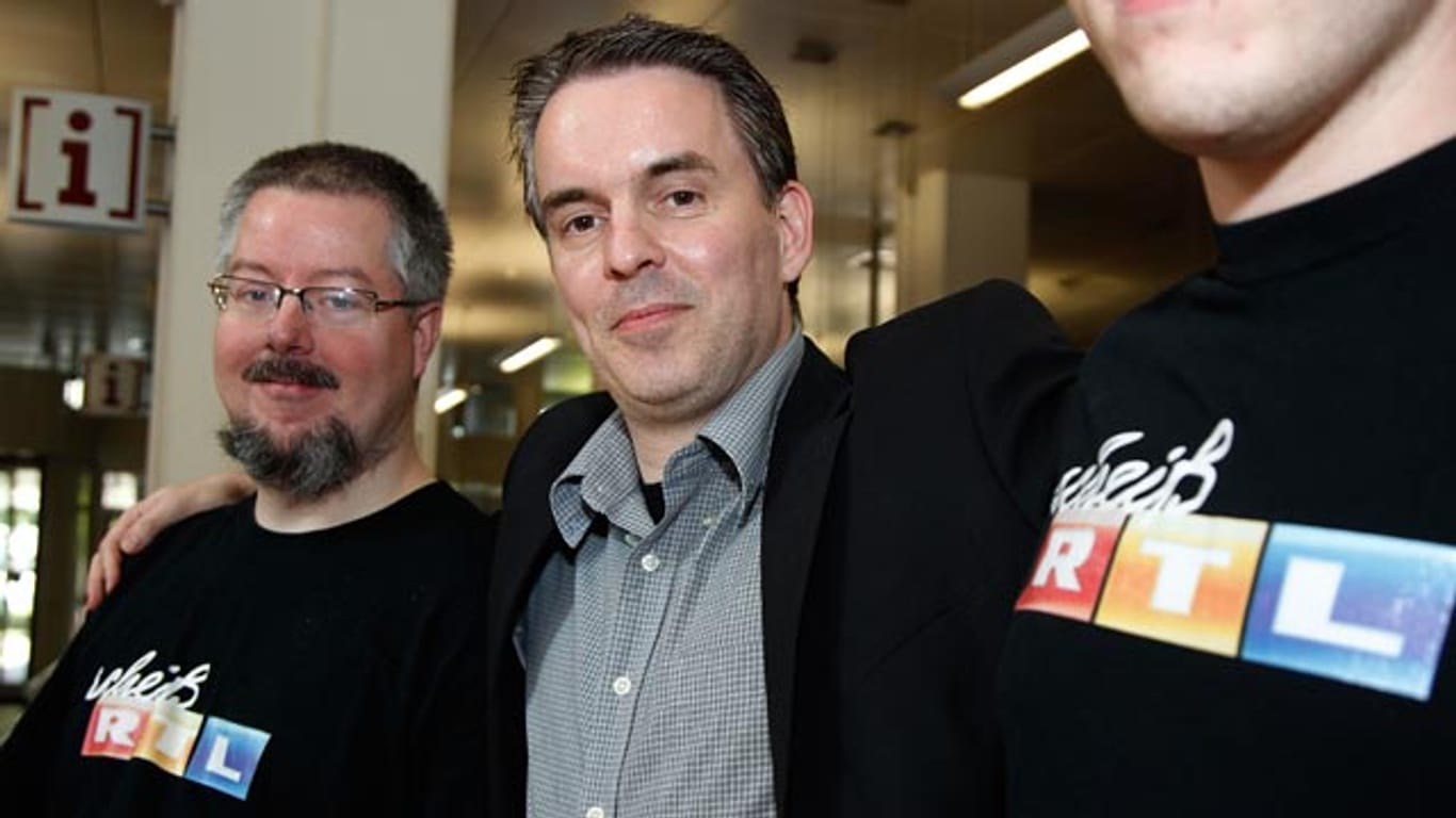 Fernsehkritiker Holger Kreymeier (M.) zusammen mit zwei Fans, die die beanstandeten T-Shirts tragen.