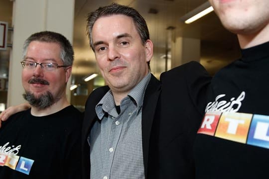 Fernsehkritiker Holger Kreymeier (M.) zusammen mit zwei Fans, die die beanstandeten T-Shirts tragen.