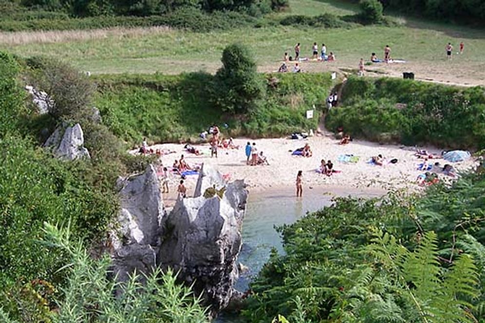 Der Gulpiyuri Beach in Asturien ist von sattem Grün umgeben.
