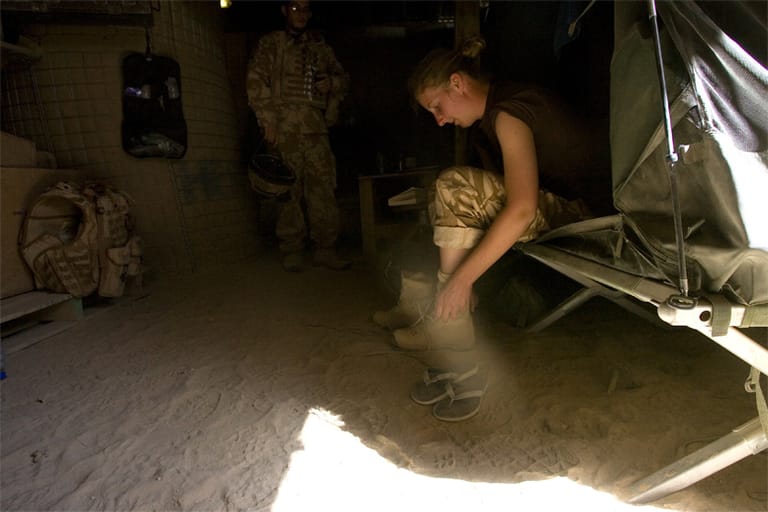 Captain Liz Barneby zieht in einem Camp in Afghanistan ihre Schuhe an und macht sich für den Dienst fertig.