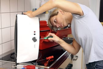 Frau repariert Toaster