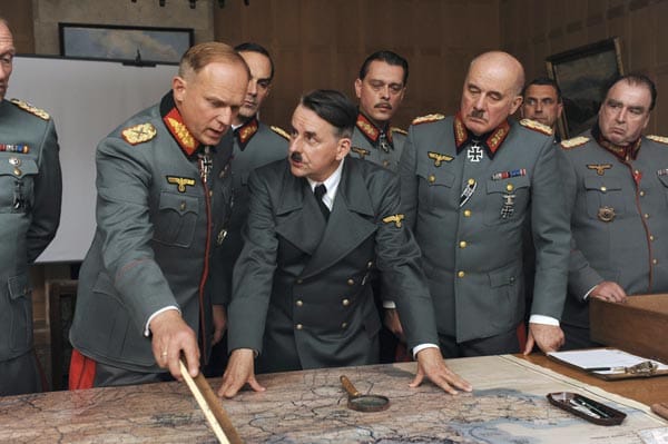 Die Lage ist angespannt. Hitler (Johannes Silberschneider) und sein Generalstab stehen Rommels Plänen, wie eine mögliche Invasion alliierter Streitkräfte verhindert werden soll, skeptisch gegenüber. Die Lage ist angespannt. Hitler (Johannes Silberschneider) und sein Generalstab stehen Rommels Plänen, wie eine mögliche Invasion alliierter Streitkräfte verhindert werden soll, skeptisch gegenüber.