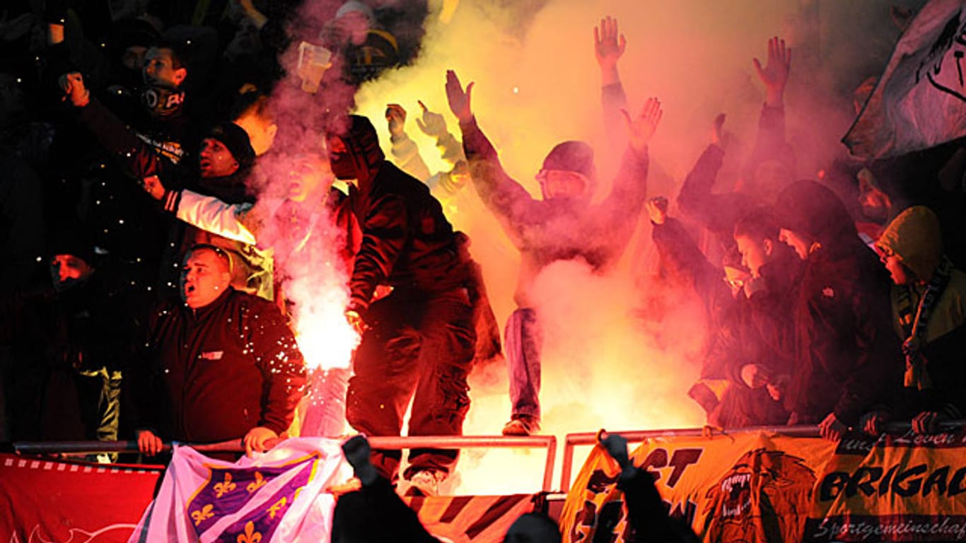 Während des Spiels zwischen Hannover und Dresden wird in beiden Fanblöcken Pyrotechnik gezündet.