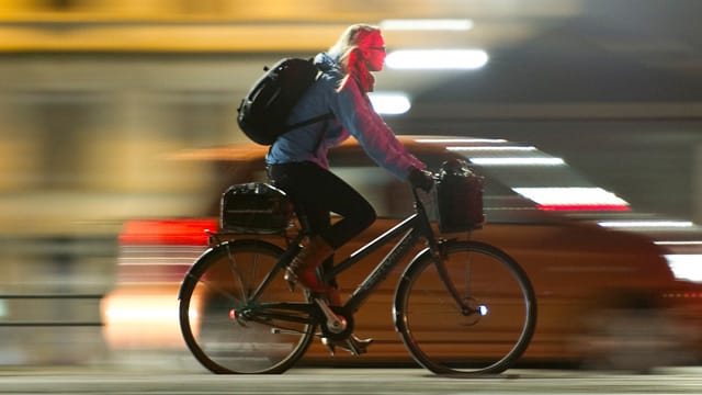 Fahrradfahrerin in Kopenhagen bei Nacht.