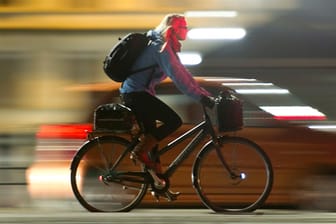 Fahrradfahrerin in Kopenhagen bei Nacht.