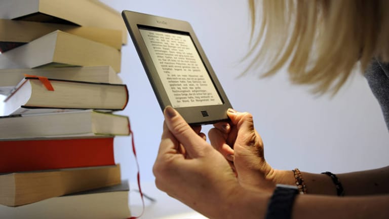 Eine Frau liest ein Buch mit einem E-Book-Reader von Amazon.