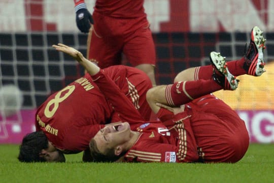Holger Badstuber (vorne) krümmt sich mit schmerzverzerrtem Gesicht auf dem Rasen.