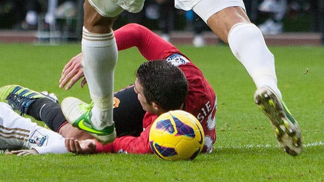 Swanseas Kapitän Ashley Williams schießt den Ball trotz Unterbrechung gegen den am Boden liegenden Robin van Persie. Swanseas Kapitän Ashley Williams schießt den Ball trotz Unterbrechung gegen den am Boden liegenden Robin van Persie.