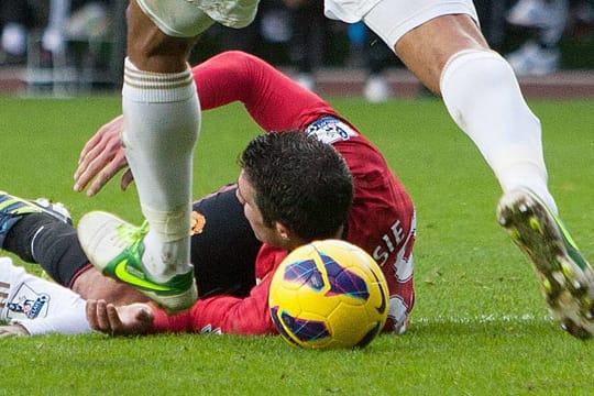 Swanseas Kapitän Ashley Williams schießt den Ball trotz Unterbrechung gegen den am Boden liegenden Robin van Persie.