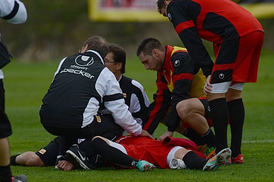 Erste Hilfe: Teamarzt, Physiotherapeut und Teamkameraden kümmern sich um den verletzten Felipe Gallegos (am Boden).