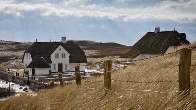 Blick aus den Dünen auf das bekannte Reetdachhaus Haus Kliffende in Kampen/Sylt