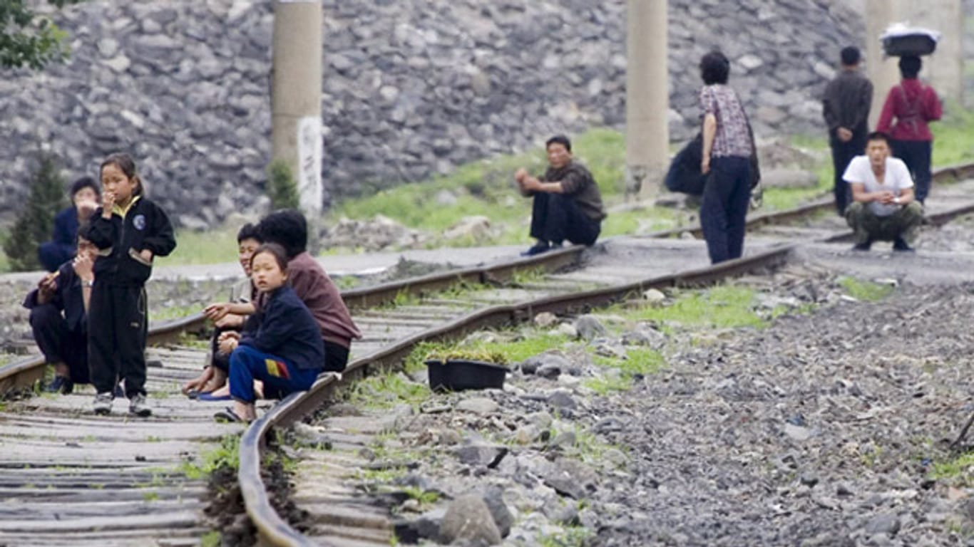 Verarmtes Land: Nordkoreaner sitzen auf einer kaum benutzten Bahnstrecke