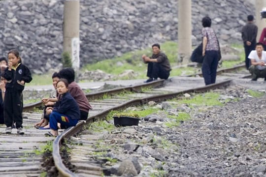 Verarmtes Land: Nordkoreaner sitzen auf einer kaum benutzten Bahnstrecke