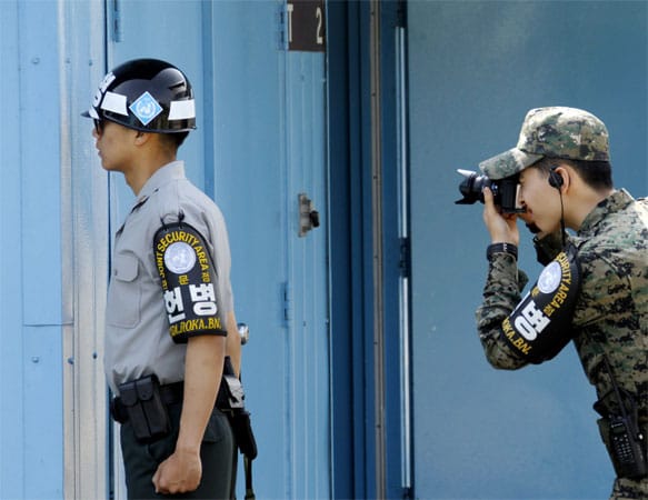 Ein südkoreanischer Soldat blickt Richtung Nordkorea, während sein Kamerad ein Foto macht. Die beiden befinden sich nahe dem Dorf Panmunjom, in der Demilitarisierten Zone. Hier herrscht Waffenstillstand.