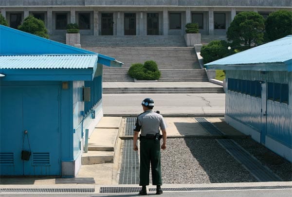 Zur gemeinsamen Sicherheitszone, auf Englisch "Joint Security Area", gehören auch drei hellblaue Holzbaracken. Sie stehen mitten auf der Grenze und können sowohl von nord- als auch von südkoreanischer Seite betreten werden.