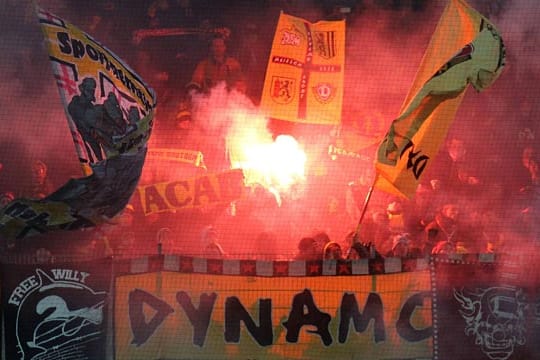 Dresdner Fans zünden während eines Spiels Bengalos.