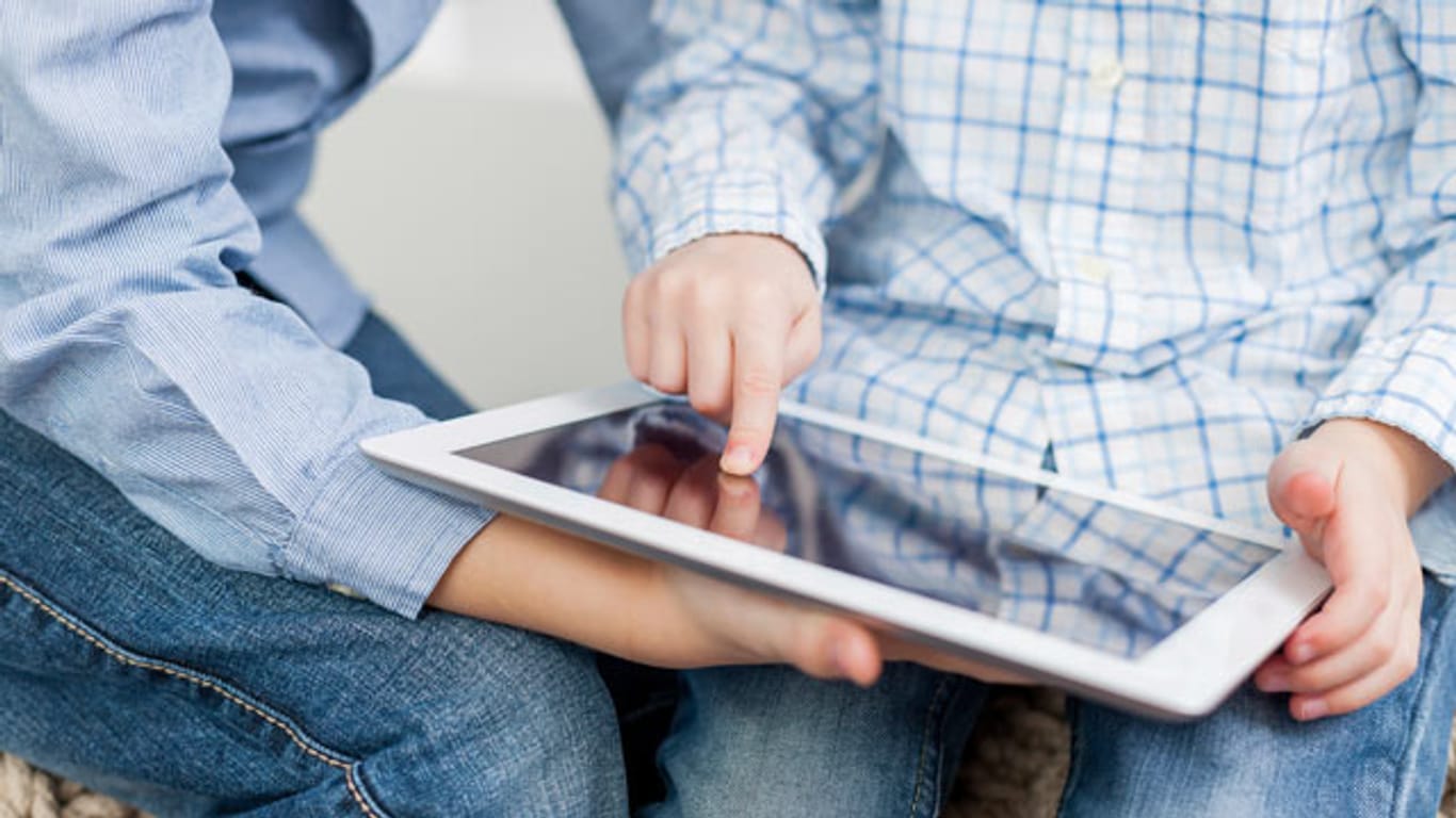 Zwei Kinder benutzen einen Tablet-PC.