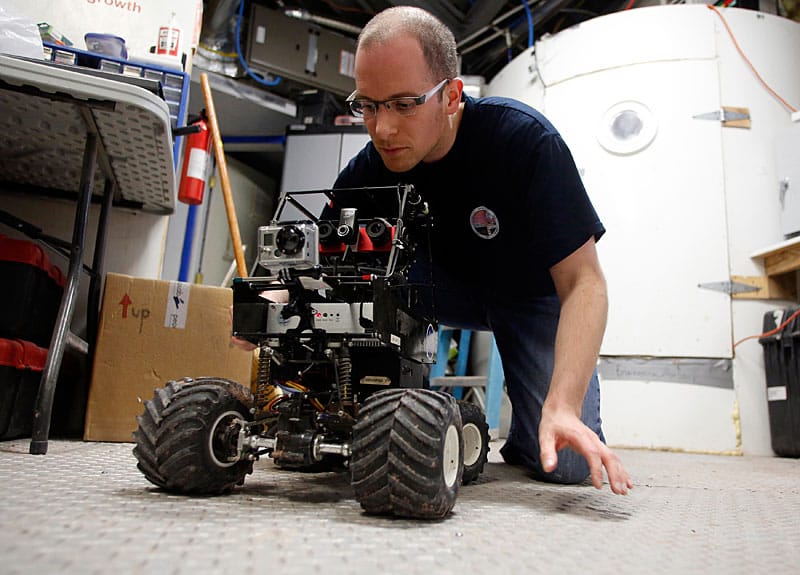 Matt Cross tüftelt an einem Rover. Mars-Roboter kommen bereits auf dem roten Planeten zum Einsatz, um Bilder zur Erde zu senden und Gesteinsproben zu sammeln.