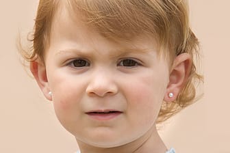 Schon kleine Mädchen sind von Schmuck wie Ohrringen fasziniert.