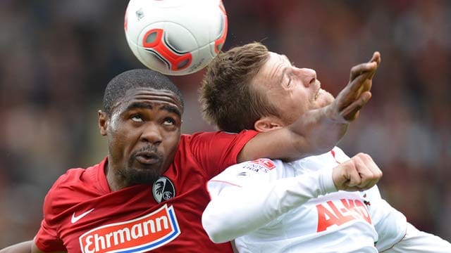 Freiburgs Cedric Makiadi (li.) beim Kopfballduell mit Augsburgs Daniel Baier.