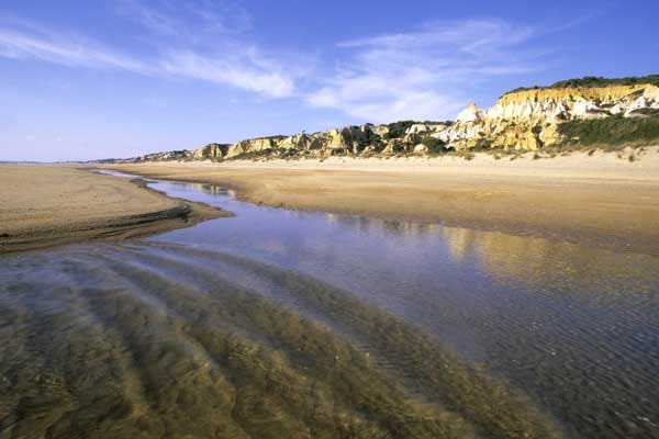 Der 13 Kilometer lange Atlantik-Strand bei Huelva in Spanien ist ein schönes, meist ruhiges Badeziel. Richtig spannend wird es am südlichen Ende, wo der Strand in den Nationalpark Coto de Doñana übergeht.