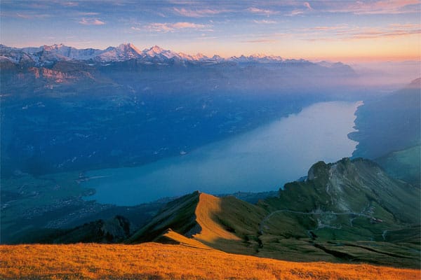 Als wäre er einem Bilderbuch entsprungen: Der türkisfarbene Brienzersee erstreckt sich im Kanton Bern und wird von der imposanten Bergkulisse des Berner Oberlands umrahmt.