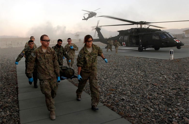 In Uniform sind alle gleich: Männliche und weibliche US-Soldaten der125 BSB Medical Company bringen einen angeschossenen Kameraden in den Lazarettbereich eines Camps in Afghanistan.