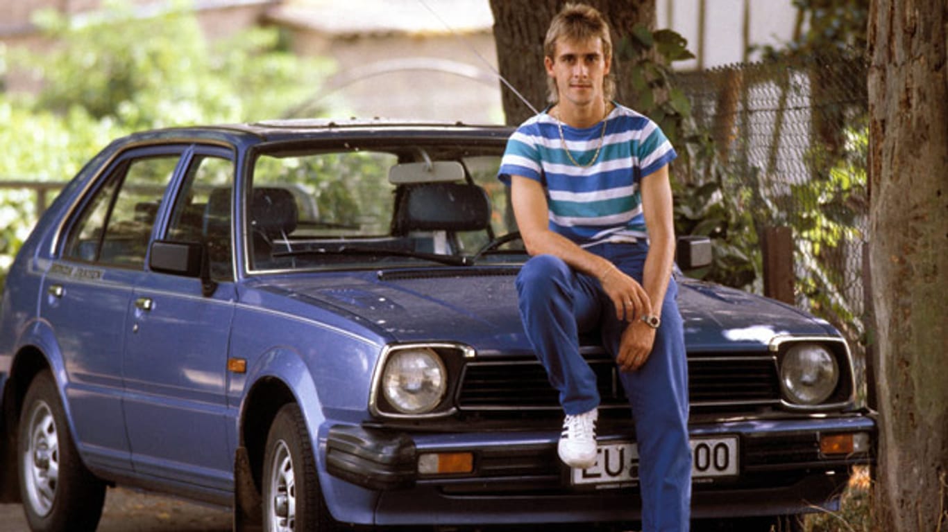 Pierre Littbarski posiert 1983 auf der Motorhaube seines Autos.