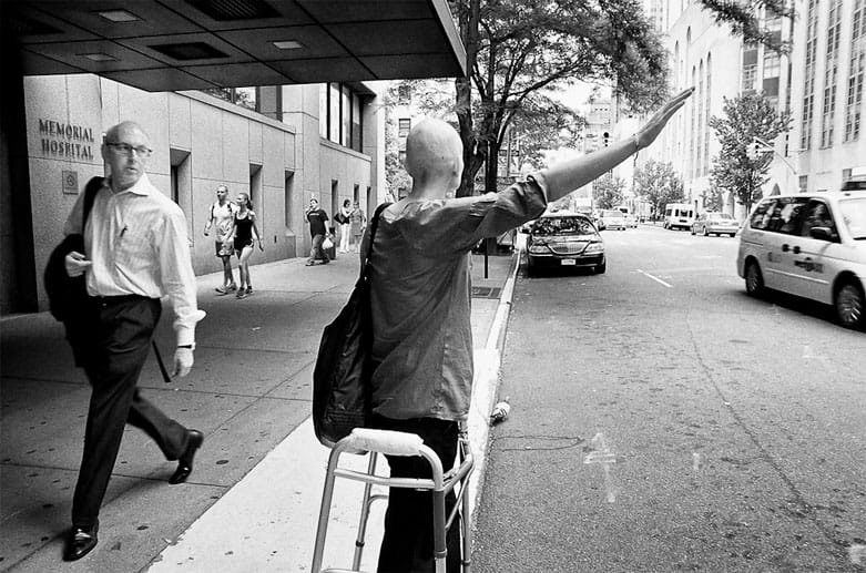 Ein fremder Mann starrt auf Jennifer, die vor dem Krankenhaus ein Taxi heranwinkt.