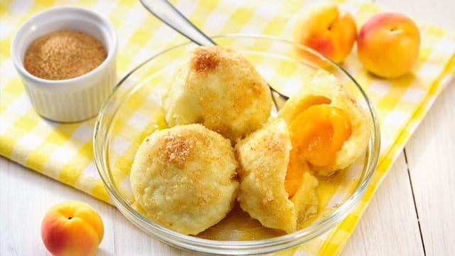 Marillenknödel: Erst in goldgelben Butterbröseln gewendet und mit Zimt und Zucker bestäubt werden sie zur perfekten Süßspeise.