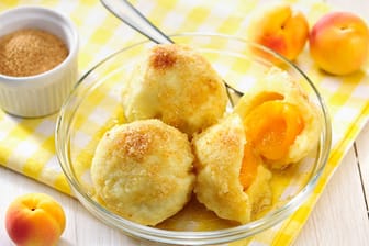 Marillenknödel: Erst in goldgelben Butterbröseln gewendet und mit Zimt und Zucker bestäubt werden sie zur perfekten Süßspeise.