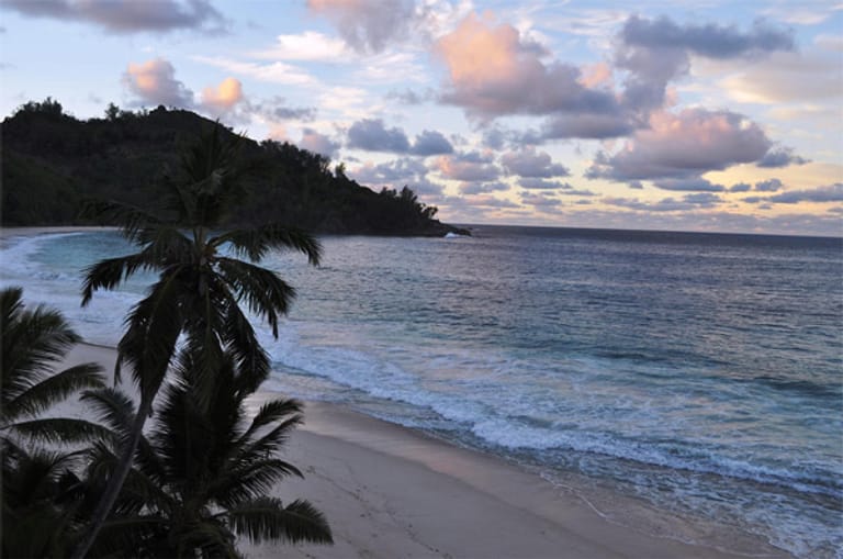 Die Bucht Anse Intendance auf Mahé in der Dämmerung. Die Seychellen sind besonders bei Honeymoonern beliebt, die hier die Strandromantik genießen.