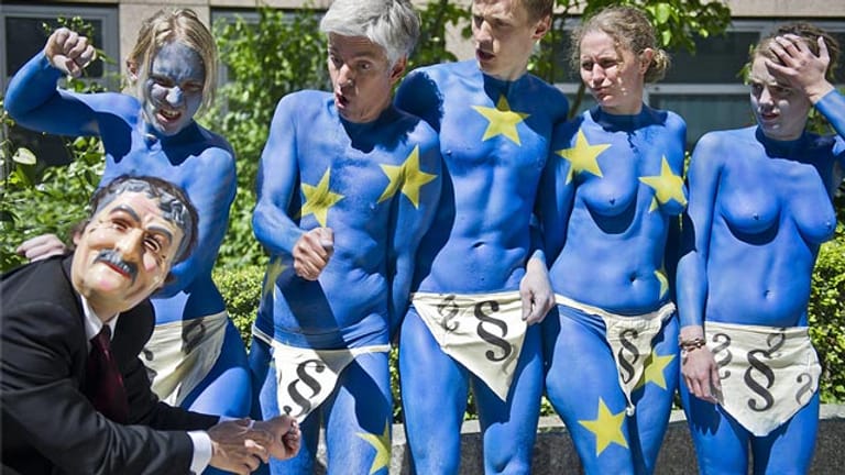 Nackte Aktivisten, die eine aufgemalte Euroflagge auf dem Körper tragen, posieren in Berlin vor dem Bundesinnenministerium.