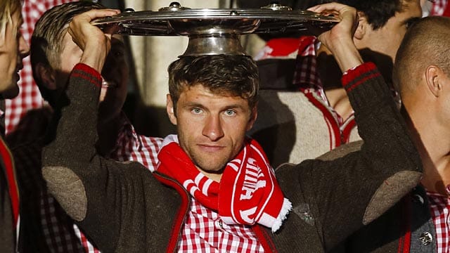 Thomas Müller präsentiert die Meisterschale auf dem Münchner Rathausbalkon. Thomas Müller präsentiert die Meisterschale auf dem Münchner Rathausbalkon.