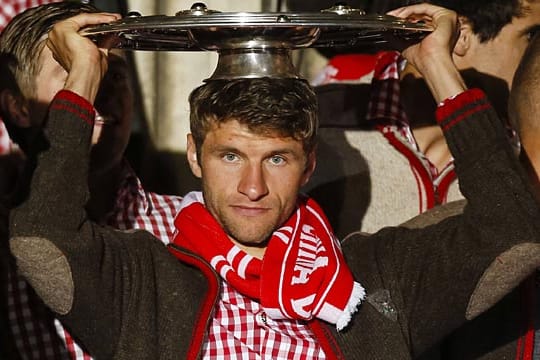 Thomas Müller präsentiert die Meisterschale auf dem Münchner Rathausbalkon.