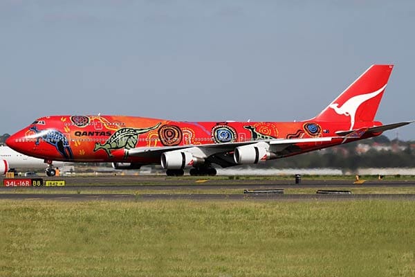Dieses Flugzeug von Qantas war zeitweise auch sehr bunt. 1994 wurde rd über der leuchtend roten Grundfarbe mit teilweise ins Orange übergehenden Abschnitten mit Motiven der Aborigines bemalt, die die Schöpfungsgeschichte des Kängurus darstellen soll.