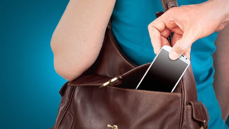 Handy-Dieb zieht einer Frau das Smartphone aus der Tasche.