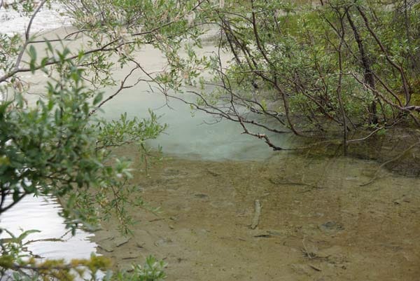 In einem Seitenarm des Flusses lässt sich das Prinzip gut beobachten: Vorne ist das Wasser klar, mit zunehmendem Gestein färbt sich das Wasser von Türkis zu Grau.