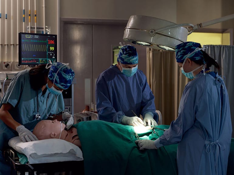 Ärzte, Krankenpfleger und Studenten üben einen medizinischen Eingriff im Operationssaal.