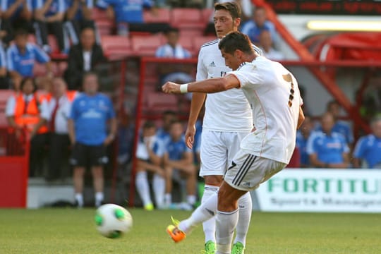 Mesut Özil (li.) schaut sich den Freistoß von Cristiano Ronaldo genau an.